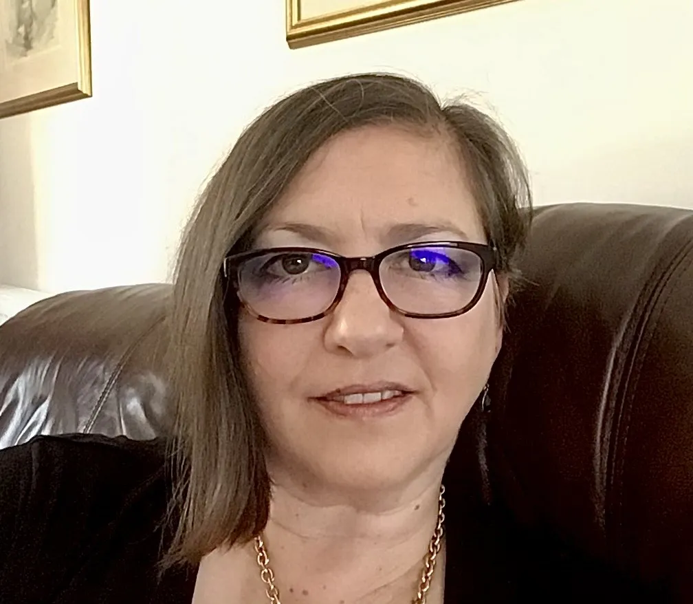 A head and shoulders image of Dawn Harding who has shoulder length straight brown hair and is wearing glasses. 