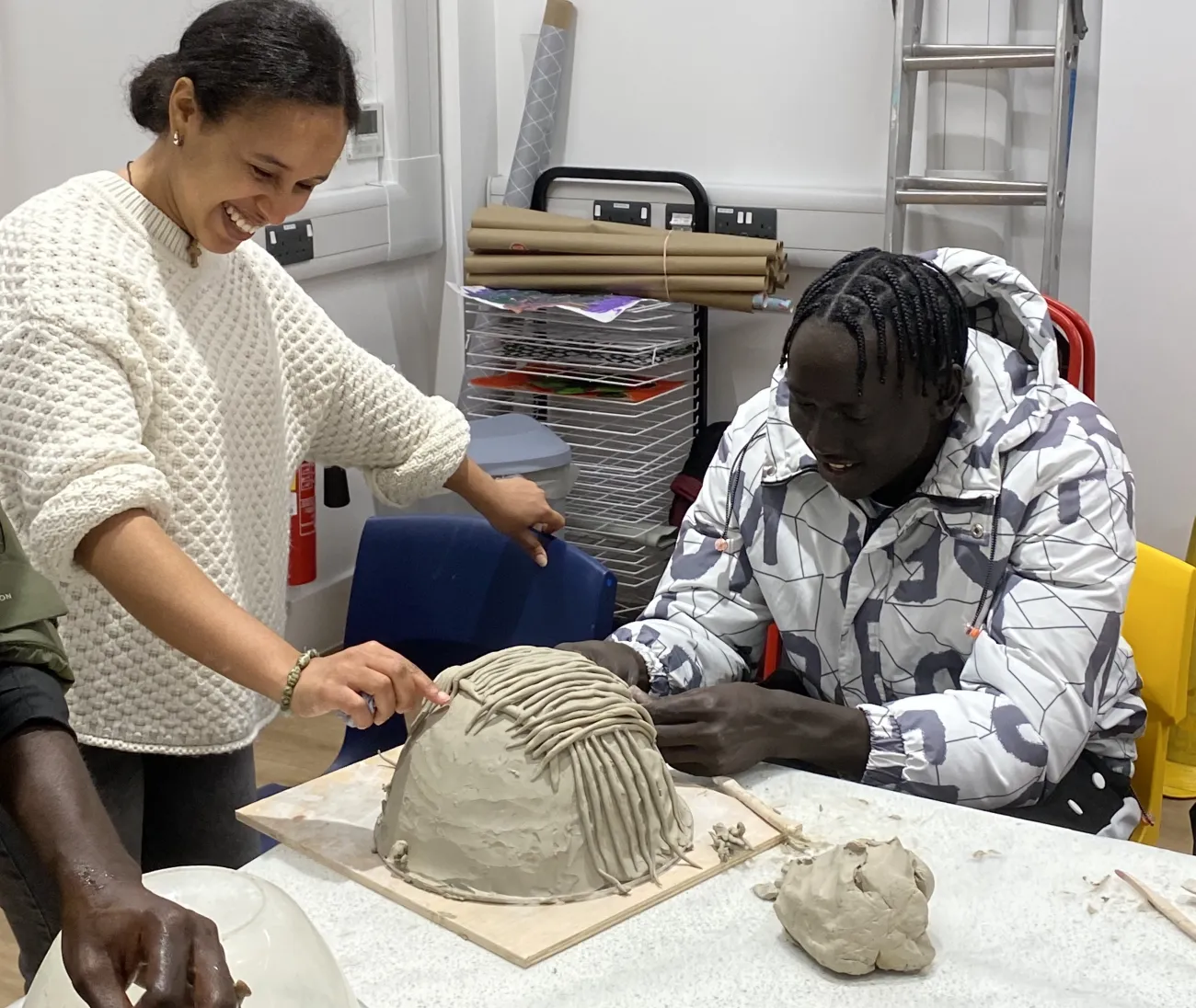 Two young people making a clay model.