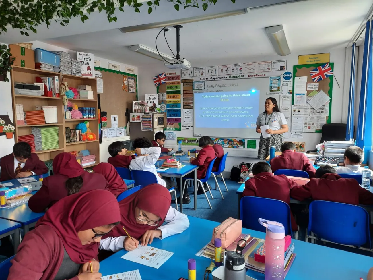 A ClimateEd volunteer speaking in a classroom 