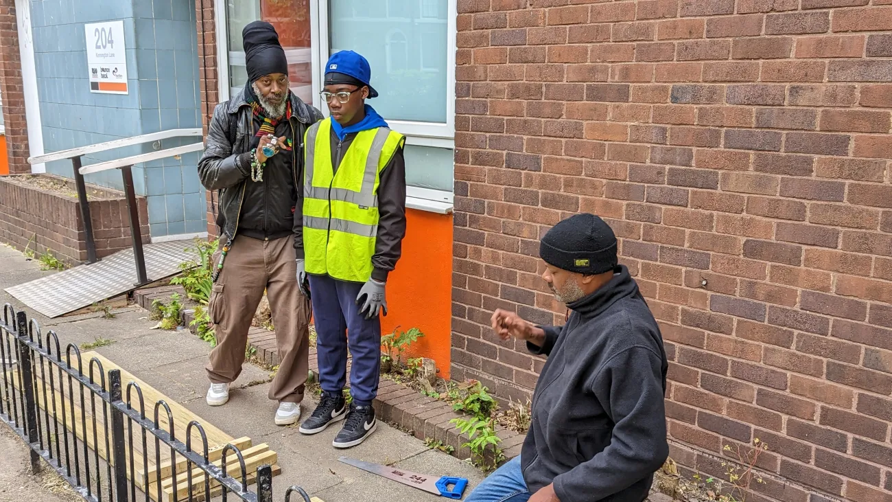 A YourStory mentor working with a young person to make a raised flower bed.
