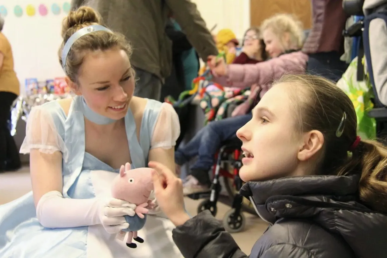 A volunteer from Make A Smile dressed as a Disney Princess meets children.