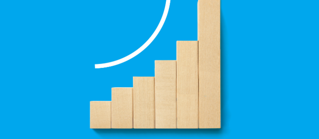 Image shows a light blue background with a gradually increasing bar graph made of wooden blocks and a white arrow above the bars to indicate growth
