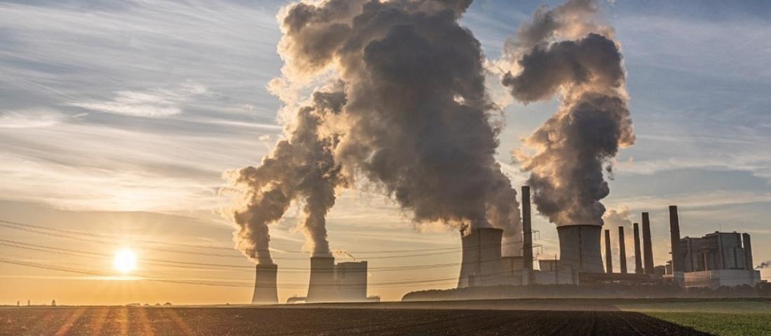 Powerplant at sunset or sunrise, with steam rising from its chimneys