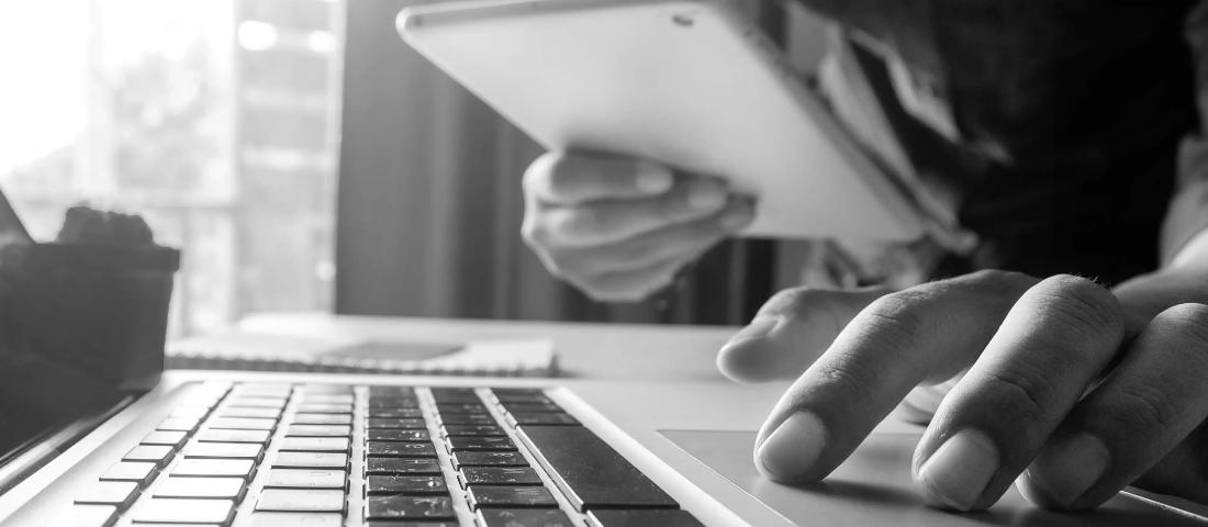 a person using a tablet and desktop