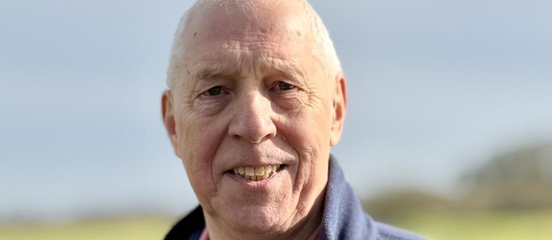 A picture of a smiling man in a dark blue fleece