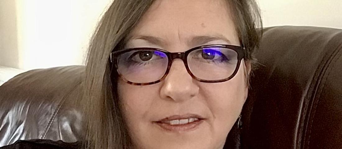 A head and shoulders image of Dawn Harding who has shoulder length straight brown hair and is wearing glasses. 