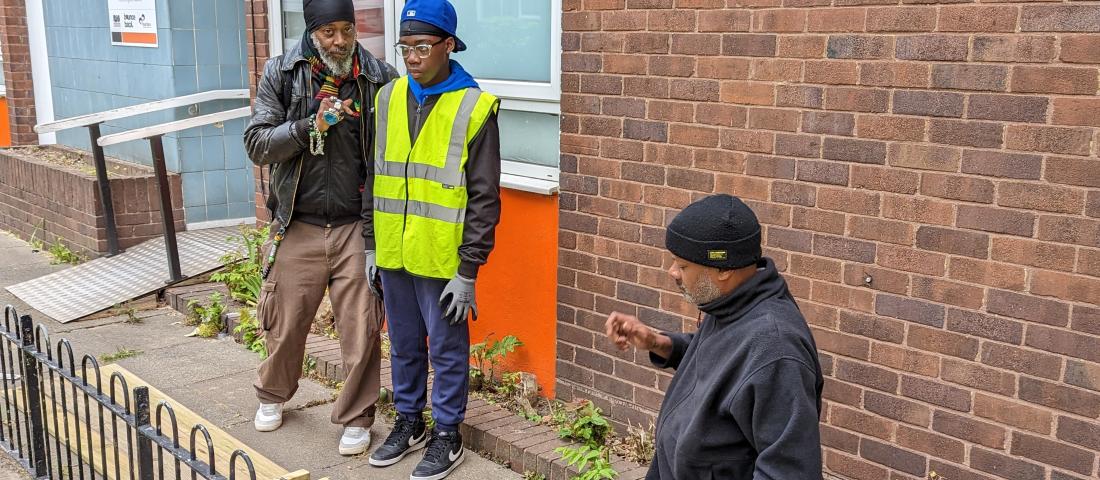 A YourStory mentor working with a young person to make a raised flower bed.