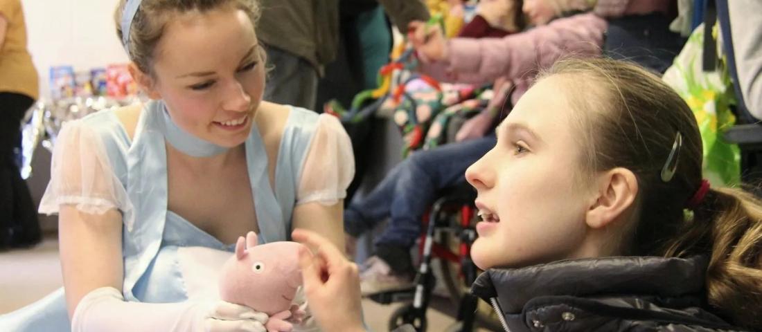 A volunteer from Make A Smile dressed as a Disney Princess meets children.